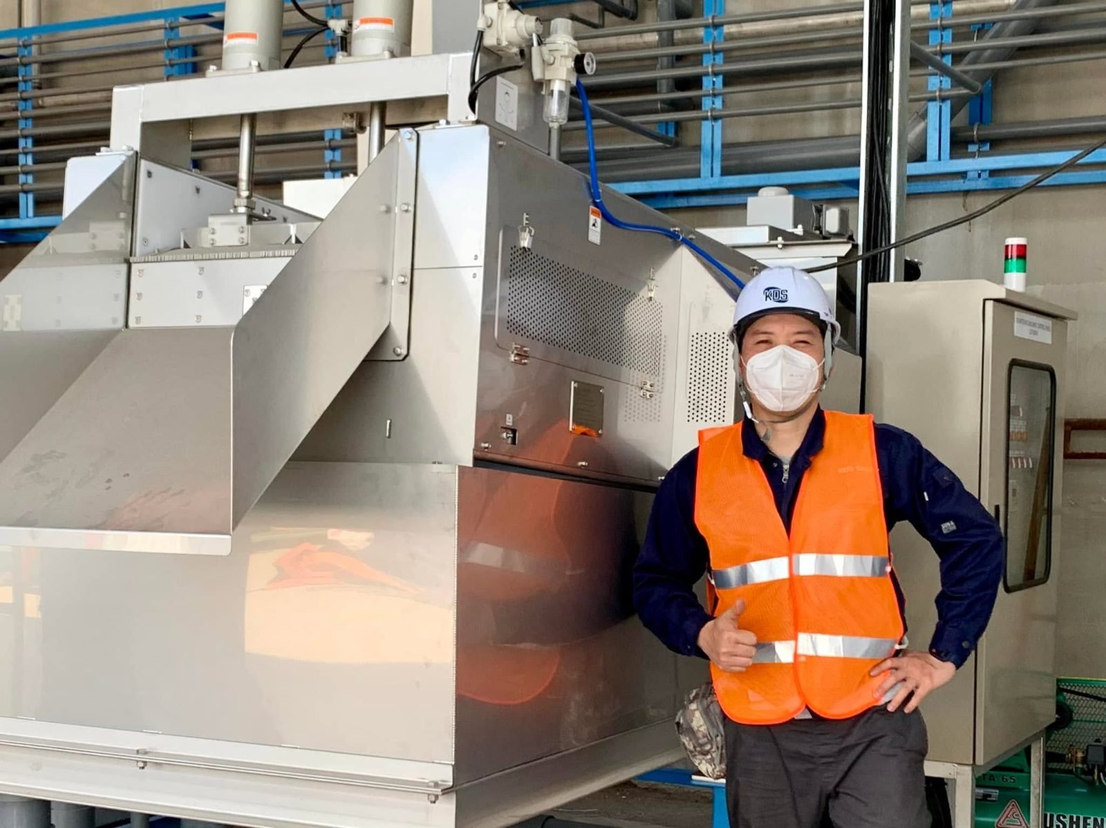 Kỹ sư đứng cạnh hệ thống ép bùn trong một buổi chạy thử tại hiện trường